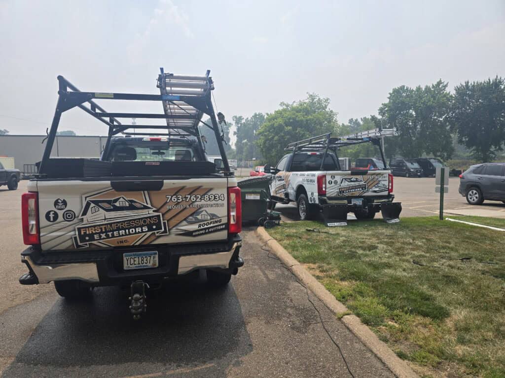 Locally owned First Impressions Exteriors roofing trucks at the company's Minnesota headquarters, representing the team that serves Twin Cities homeowners.