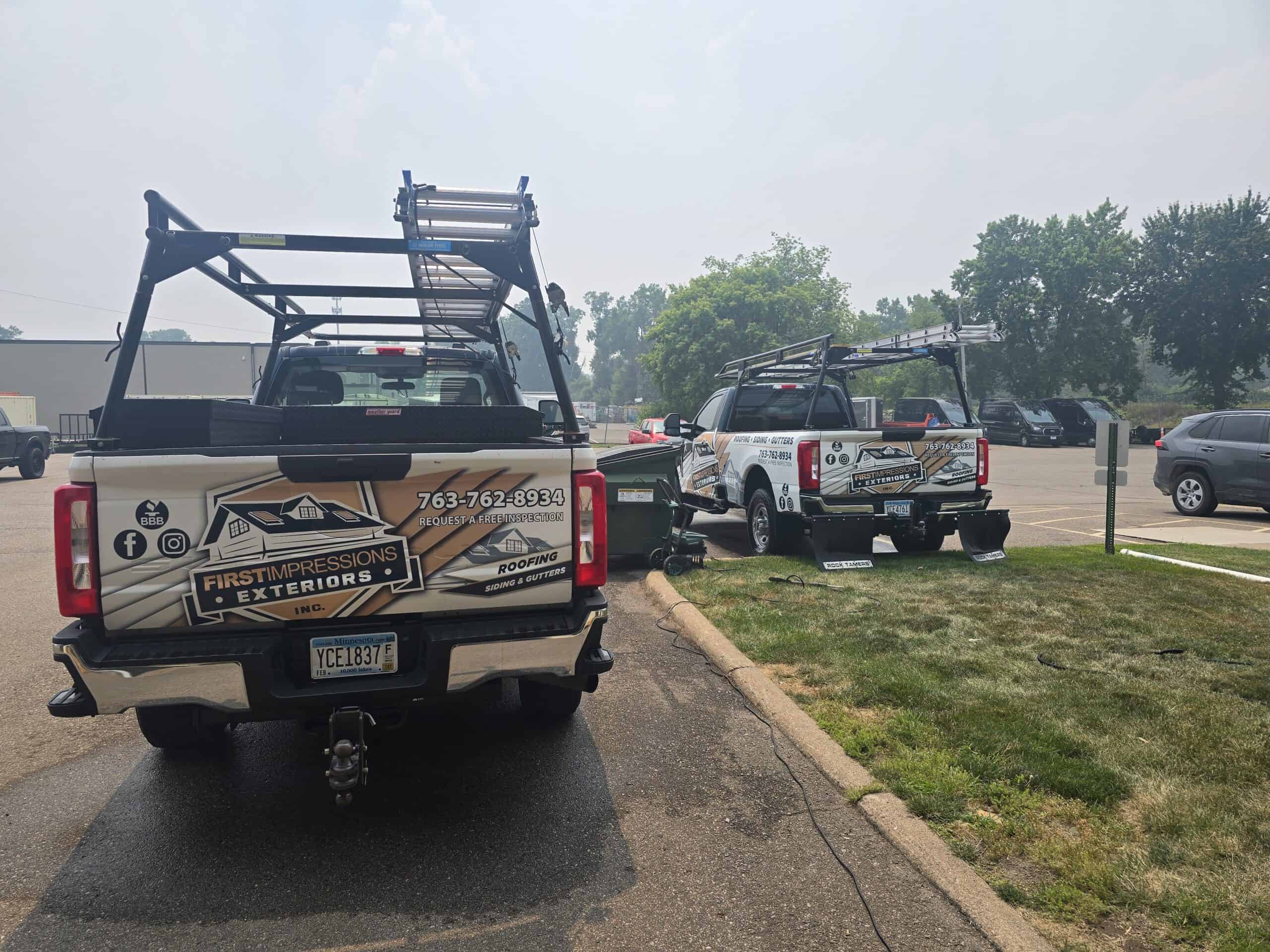 Locally owned First Impressions Exteriors roofing trucks at the company's Minnesota headquarters, representing the team that serves Twin Cities homeowners.