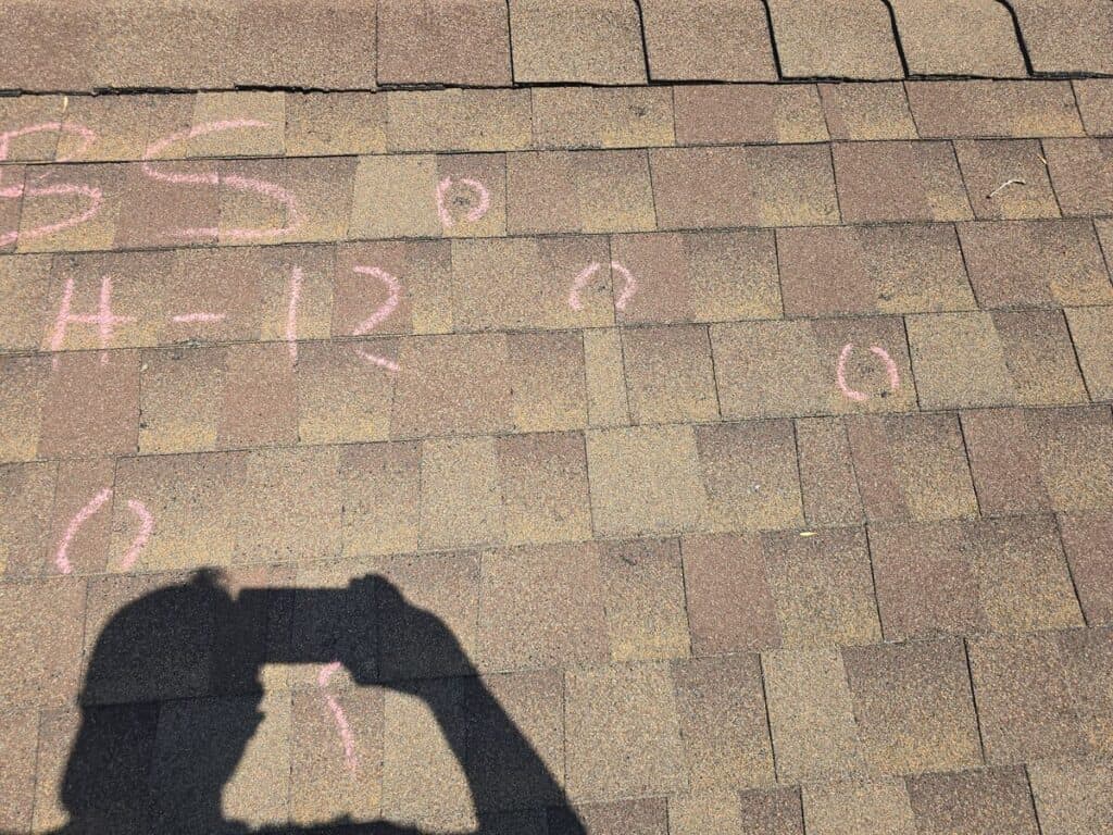 Storm damage marked on a Minnesota asphalt shingle roof