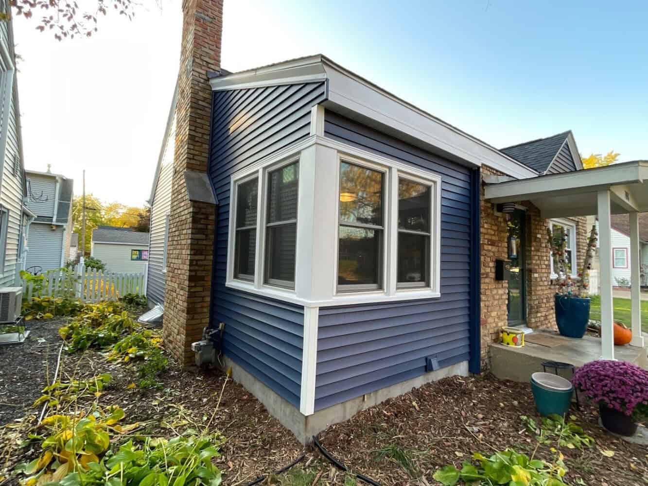 New navy vinyl siding and bay window installed on a St. Louis Park home by First Impressions Exteriors