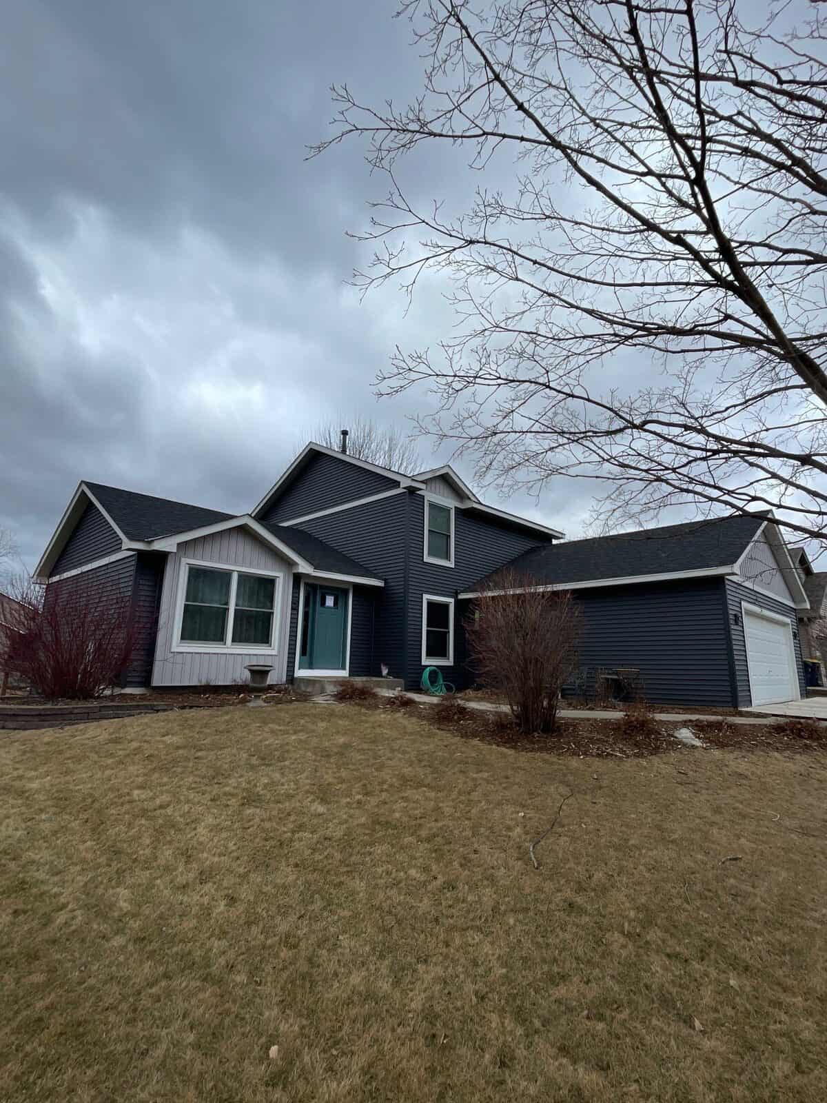 Farmington, MN home with new Mastic Carvedwood siding in Deep Cavern and an Owens Corning Duration roof in Onyx Black