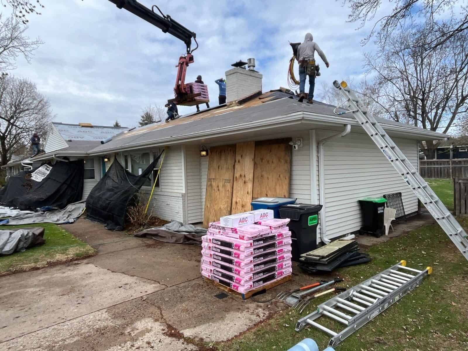 Owens Corning shingle bundles staged with windows protected during a Minneapolis, MN roof replacement