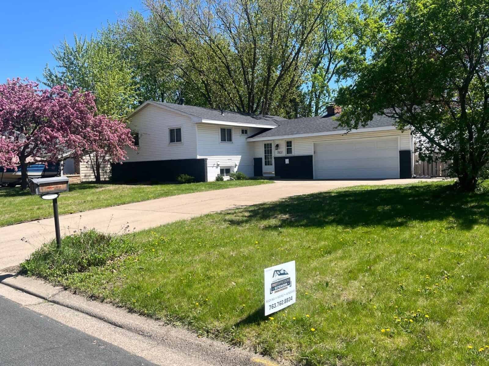 New Hope, MN home before its exterior restoration, with a First Impressions Exteriors yard sign