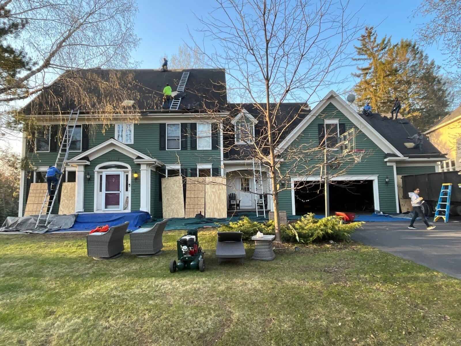 Crew installing Owens Corning Duration shingles on a steep Woodbury, MN roof