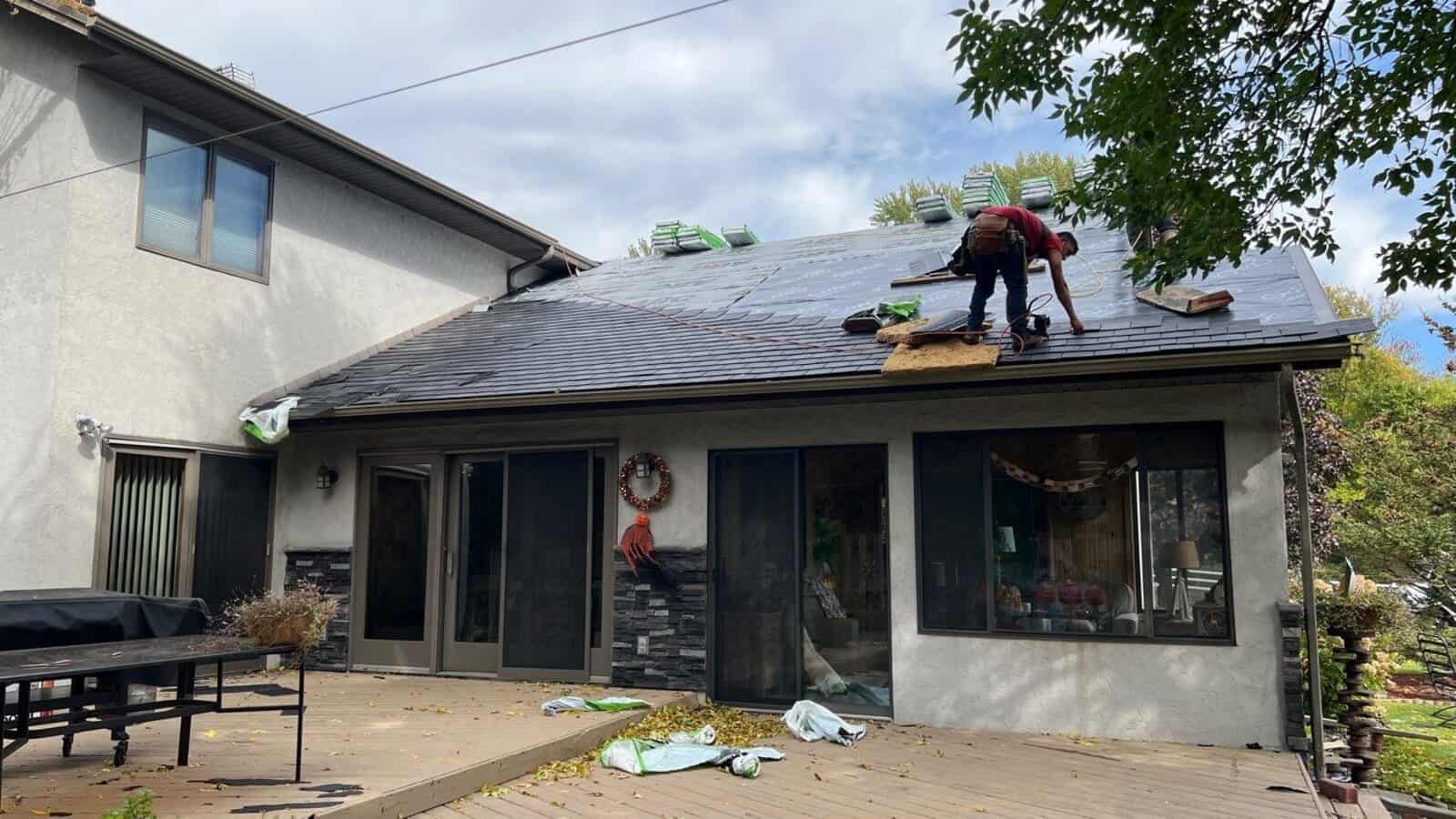Crew member working on the porch roof of a Little Canada, MN home