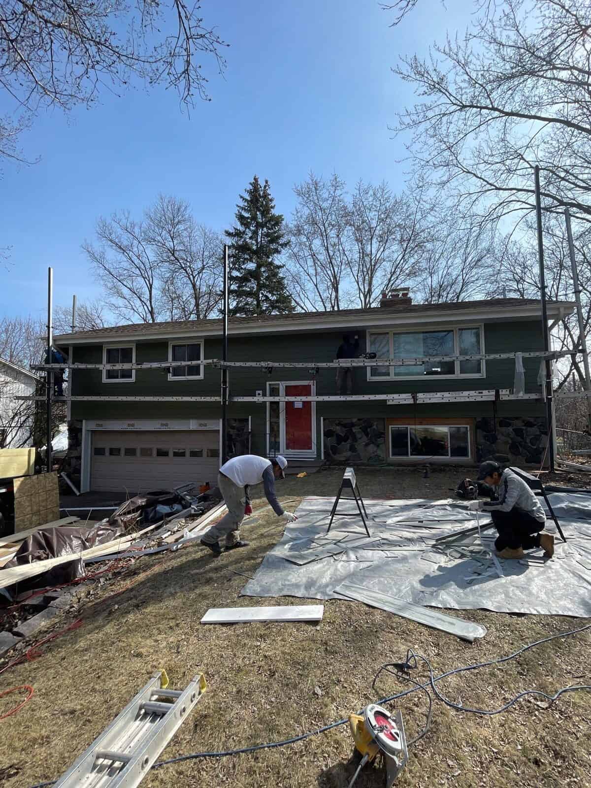 First Impressions Exteriors crew protecting landscaping during a Plymouth, MN siding installation