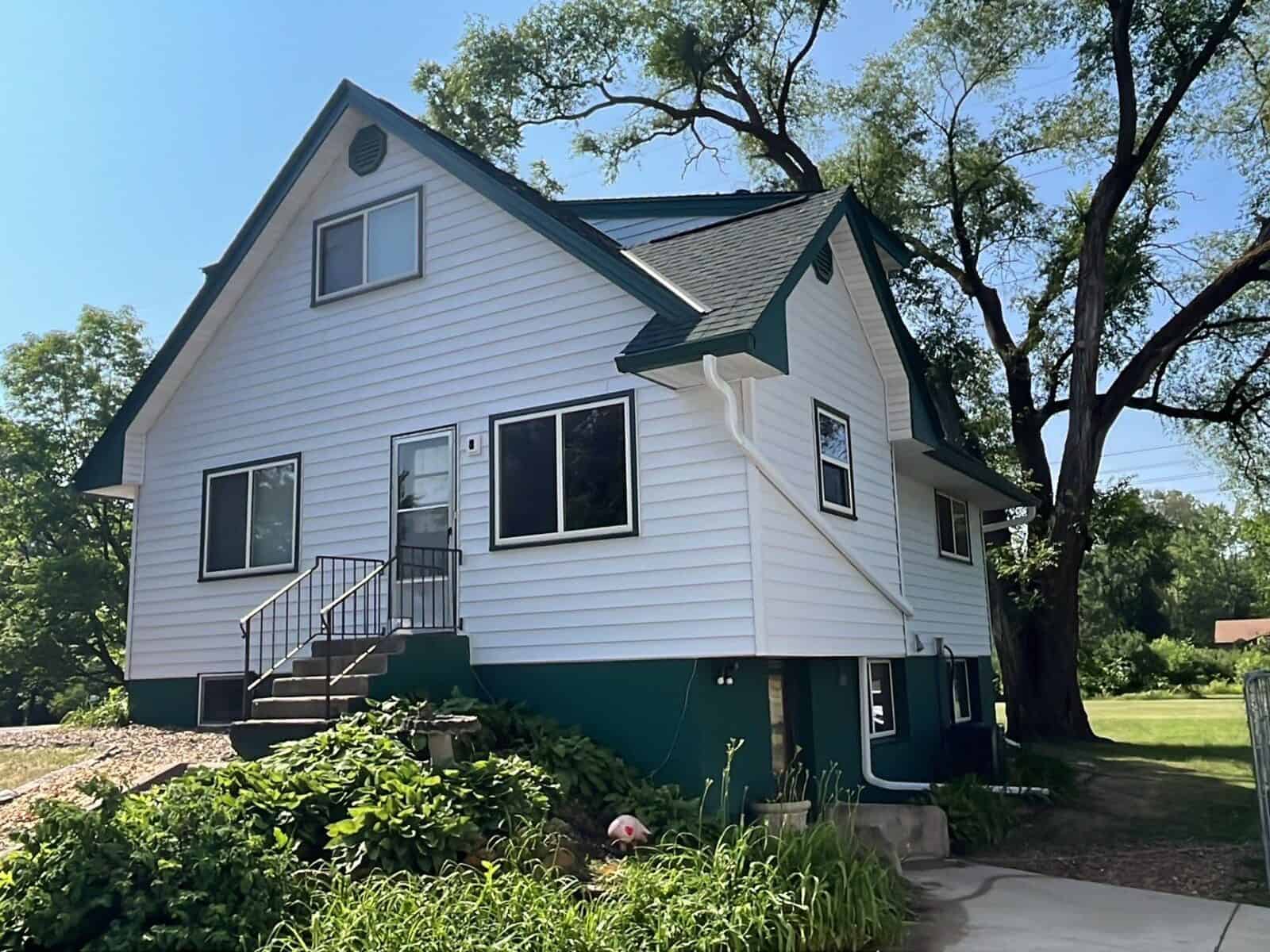 Side view of a Little Canada, MN home with new Hunter Green roof and Glacier White siding