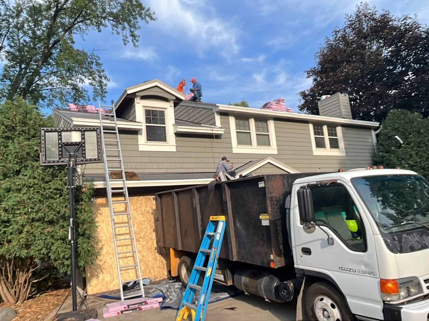 Tear-off debris going straight into the truck at a Golden Valley, MN storm restoration