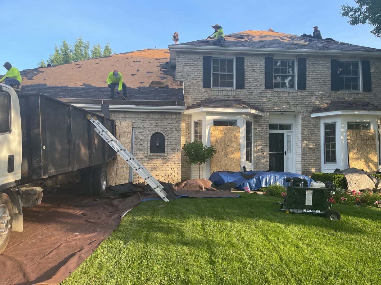 Home protected with plywood and tarps during an Eden Prairie, MN roof replacement