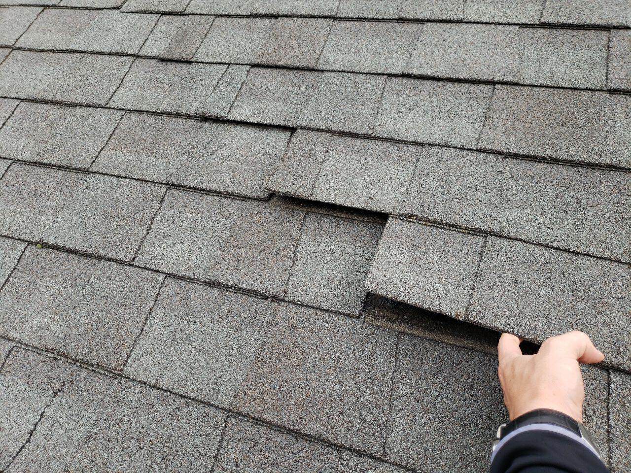 Hail hits marked on the old shingles during the inspection