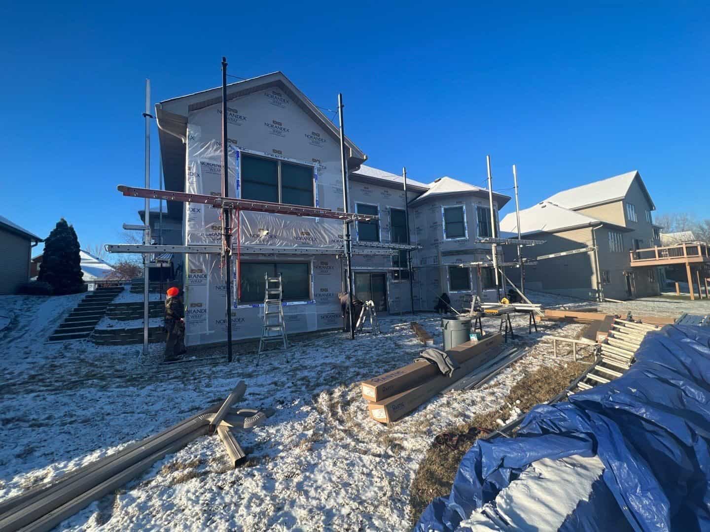 New Mastic Carvedwood siding being installed over housewrap in Osseo, MN