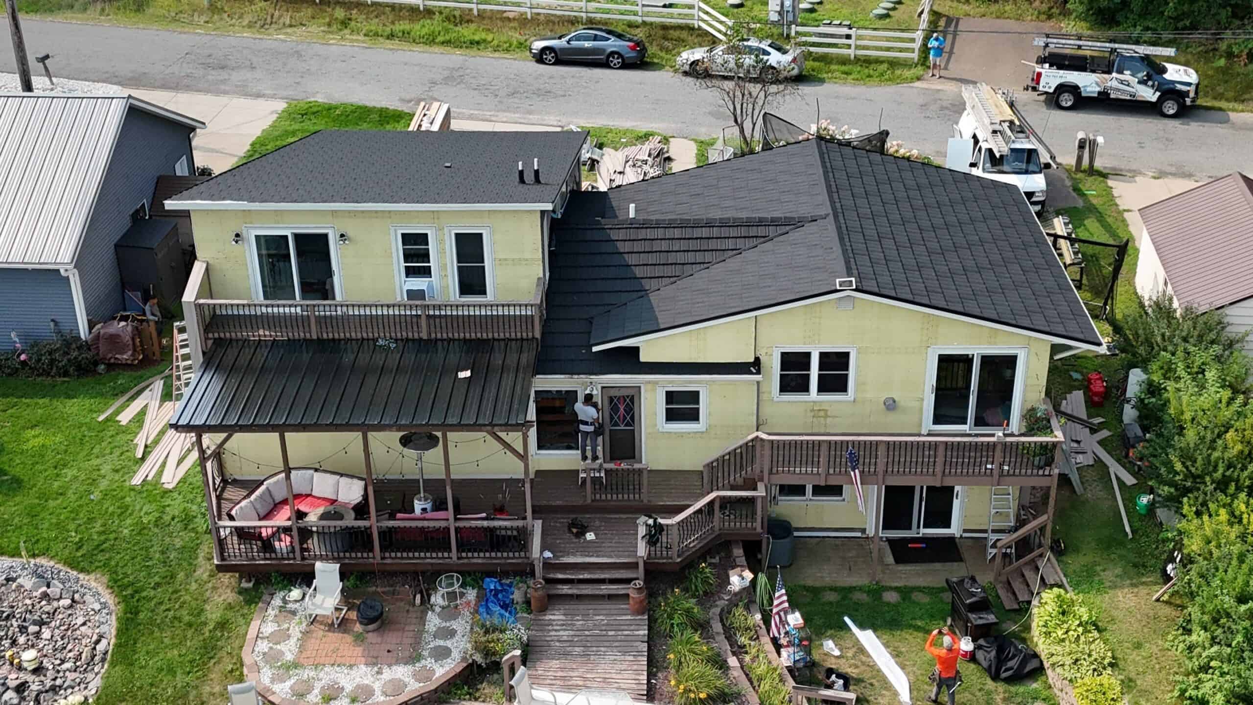 The finished front of an Altoona, WI home with a new Charcoal steel roof and Beige vinyl siding