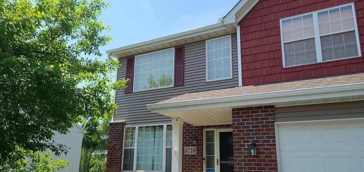 Chanhassen, MN home with a new Owens Corning Duration roof in Teak, Mastic Carvedwood siding in Rugged Canyon, and Cedar Discovery shakes in Russet Red