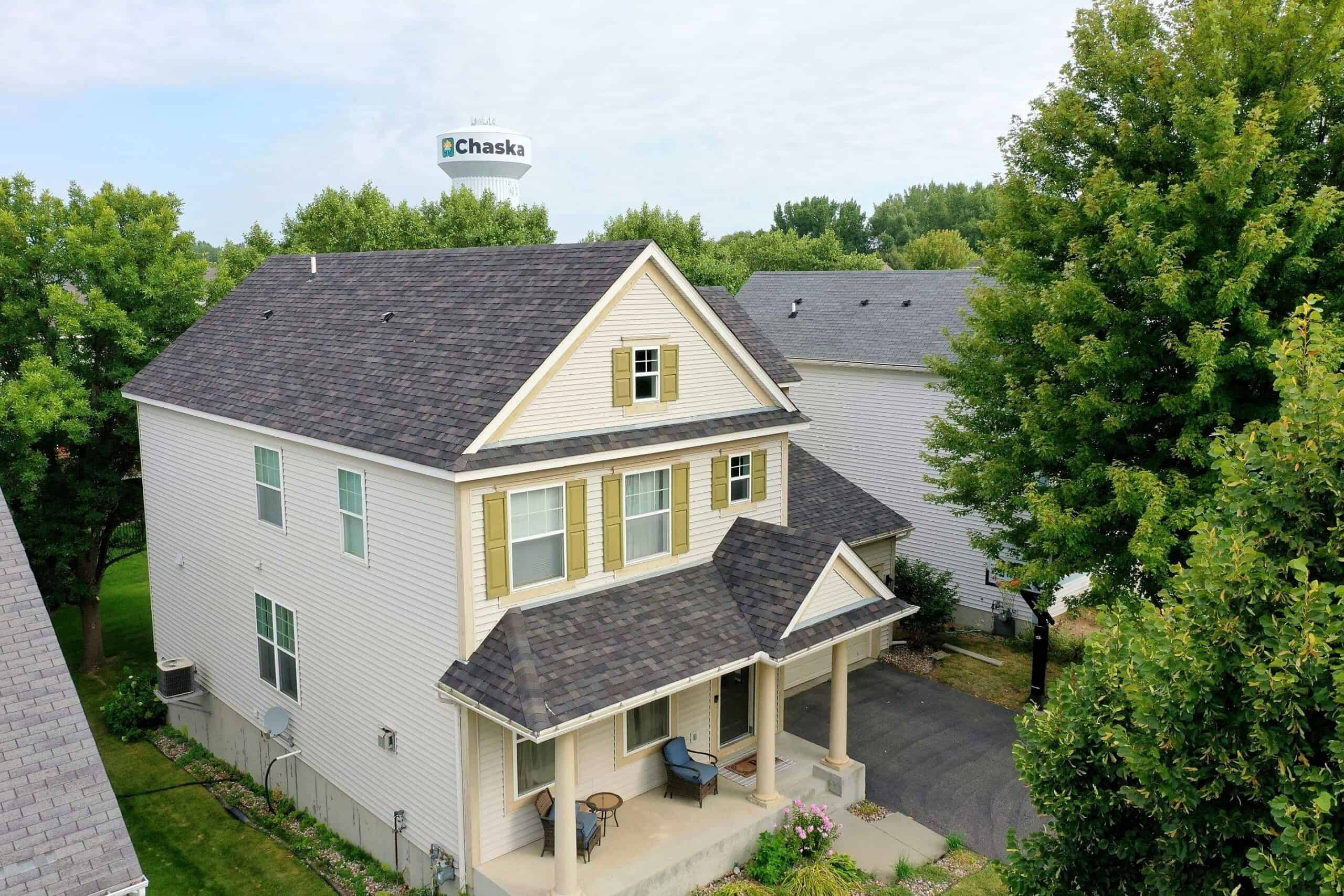 Completed residential roof in Chaska with the town water tower behind the home
