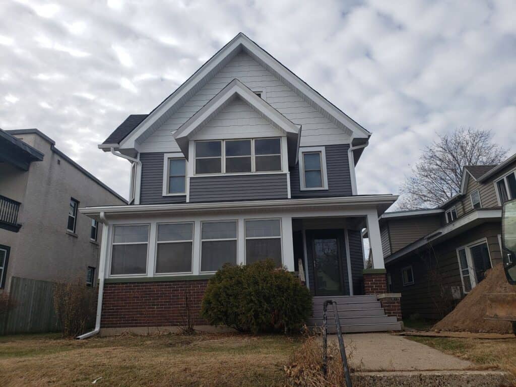 Finished exterior remodel in Minneapolis with charcoal gray steel siding, white trim and a new Onyx Black roof