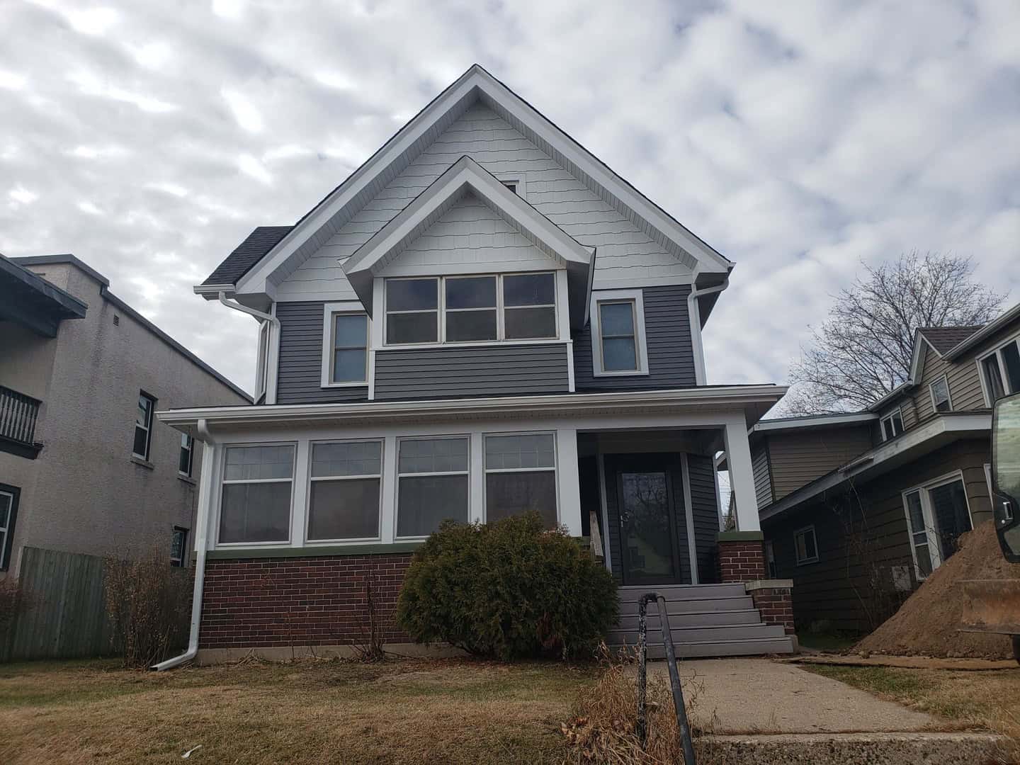 Finished exterior remodel in Minneapolis with charcoal gray steel siding, white trim and a new Onyx Black roof