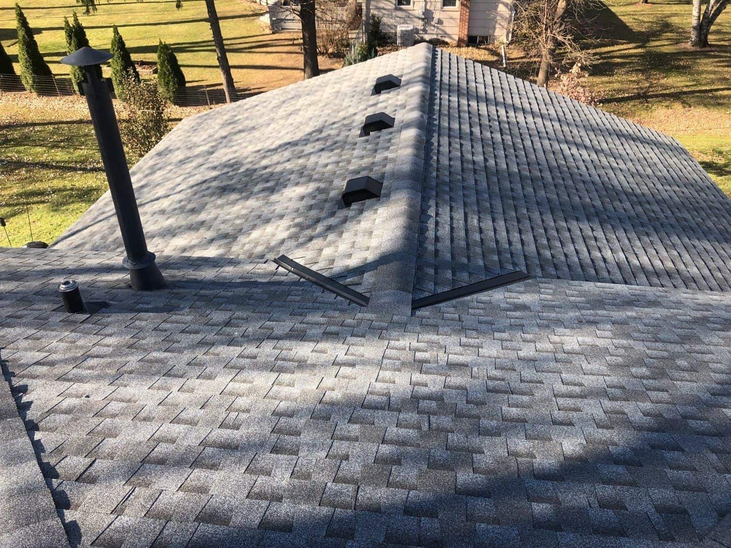 New Pewter Gray shingles across the rear planes of the Eden Prairie roof